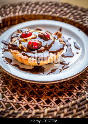 Leckere Tarte mit Schokoladenglasur und Kirschen Stockfoto