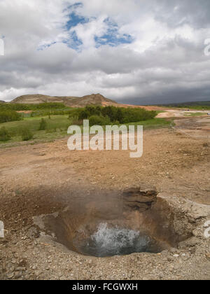 Kleine brodelnden dampfenden Geysir in Island. Stockfoto