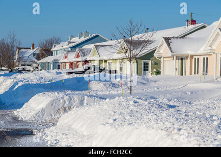 Schnee aufwärts entlang einer Gepflügtes Straße in einem nördlichen Vorort. Stockfoto