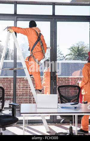 Fensterputzer am Arbeitsplatz im Büro Stockfoto