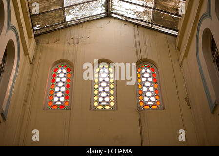 Zwei farbige Glas Fenster in einem alten Gebäude mit etwas Schmutz an den Wänden. Stockfoto