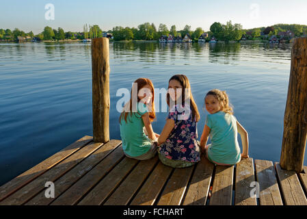 Deutschland Mirow drei Mädchen sitzt auf einem Steg am See Mirow Stockfoto