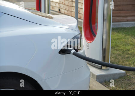 Topeka, Kansas, USA, 5. September 2015 Tesla Model S steckt in und laden an der Kompressor-Station auf der Arby Parkplatz in Topeka, Kansas. Tesla-Kompressor-Stationen ermöglichen Tesla Autos zu schnell-ChargedÑin weniger als ein HourÑat Netzwerk, für die keine Zahlung. Ab Februar 2015 gab es 2.000 Supercharger in 400 Stationen weltweit. Bildnachweis: Mark Reinstein Stockfoto