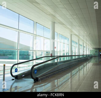 Förderband für Personen in einem leuchtenden Terminal eines Flughafens Stockfoto