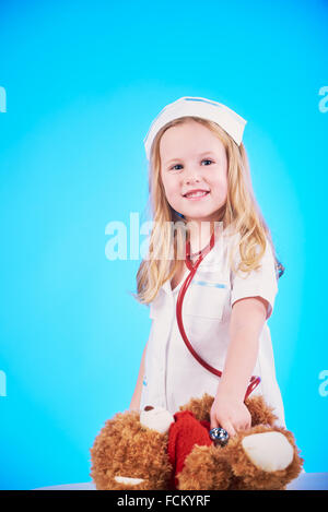 Schöne Krankenschwester Prüfer wenig krank brauner Teddybär. Stockfoto