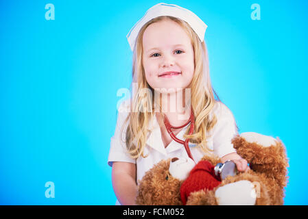 Schöne Krankenschwester Prüfer wenig krank brauner Teddybär. Stockfoto