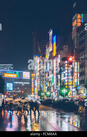 Sonnenschirme und Neonlichter spiegelt sich in den Regen, Shinjuku, Tokyo, Japan Stockfoto