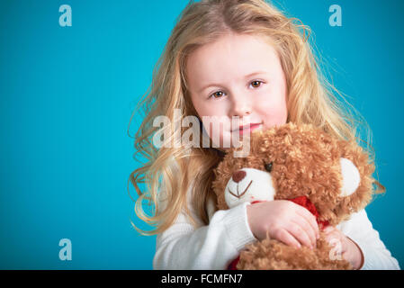 Fabelhaftes kleines Mädchen umarmt brauner Teddybär. Stockfoto