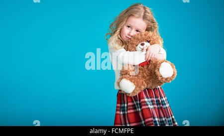 Fabelhaftes kleines Mädchen umarmt brauner Teddybär. Stockfoto