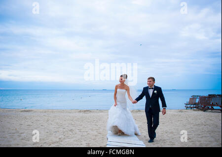 Das Brautpaar sind am Strand spazieren. Stockfoto