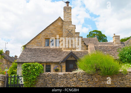 ländlichen englischen Dorf mit alten traditionellen goldenen Stein Ferienhaus mit Stein Trockenbau Cotswold, Schieferdach, Lavendel Stockfoto