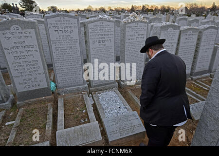 Ein religiösen jüdischer jungen zahlt Hinsicht an einen verstorbenen Verwandten in Montefiore Cemetery in Cambria Heights, Queens, New York Stockfoto