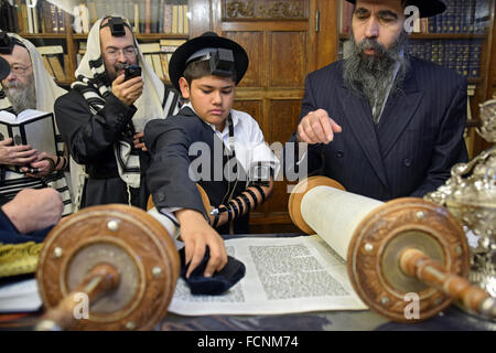 Ein religiösen jüdischer jungen nennt man die Thora für seine Bar Mizwa in Crown Heights, Brooklyn, New York Stockfoto