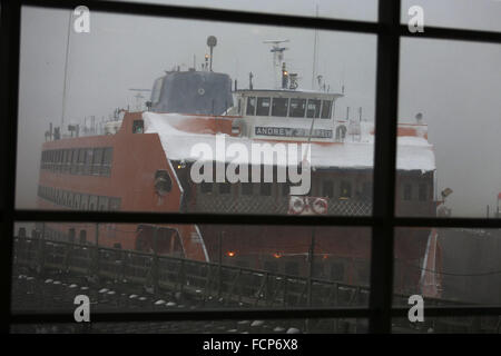 Staten Island, NY, USA. 23. Januar 2016. Die Staten Island Ferry dockt an der St. George-Terminal im Winter Sturm Jonas. Ein Reiseverbot hatte es seit Stunden, aber die Fähre noch betrieben. Schneefall Prognosen für Staten Island waren ca. 12-18 In mit Windgeschwindigkeiten in Böen bis zu 50 Meilen pro Stunde. Am späten Nachmittag Busse nicht mehr laufen und ein Reiseverbot wurde durch das NYPD durchgesetzt. Dieser Mangel an Verkehrsmitteln gestrandet viele Bewohner von Staten Island, die die Fähre nach Hause genommen hatte. Menschen waren gezwungen, zu versuchen, zu Fuß zu ihrem Bestimmungsort im Schneesturm. New Yorker Gouverneur Andrew Cuomo erklärte ein Stockfoto