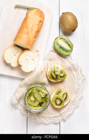 Dosen Kiwi und Brot-Scheiben, Ansicht von oben.  Kiwi in Glas im Fokus Stockfoto
