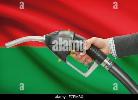 Kraftstoff Pumpe Düse in der hand mit Flagge auf Hintergrund - Burkina Faso Stockfoto