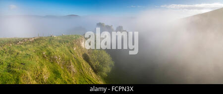 Einem nebligen Herbstmorgen in Cavedale, Castleton im Peak District National Park. Peveril Castle versteckt im Nebel. Stockfoto