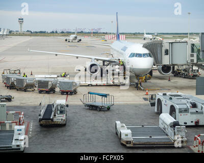 Flugzeuge auf dem Flughafen Barcelona geladen wird. Beschäftigen Sie Arbeitnehmer, Gepäckwagen, Flugzeug Schlepper Traktor. Stockfoto