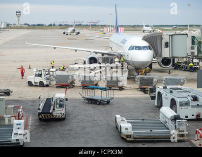 Flugzeuge auf dem Flughafen Barcelona geladen wird. Beschäftigen Sie Arbeitnehmer, Gepäckwagen, Flugzeug Schlepper Traktor. Stockfoto