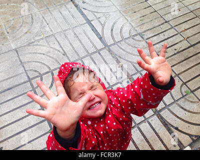 Hübsches kleines Mädchen Spaß Regen am Tag auf der Straße Stockfoto