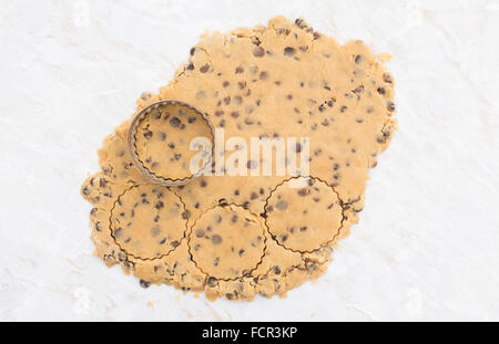 Kreise aus geschnitten ausgerollt Erdnussbutter und Schokolade-Chip-Cookie-Teig mit einem Metall cutter Stockfoto