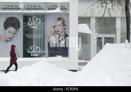 Charkiw, Ukraine. 18. Januar 2016. Eine Frau geht vorbei an einen Friseursalon hinter Bergen von Schnee in Charkow, Ukraine, 18. Januar 2016. Foto: Soeren Stache/Dpa/Alamy Live News Stockfoto