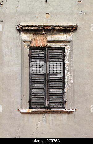 Braune Fensterläden auf einer alten weißen Wand Stockfoto