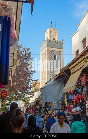 Marokkanische Bürger in eine alltägliche Szene in Grande Rue de Fès El-Jdid mit Jama El Hamra Moschee. Marokko. Stockfoto