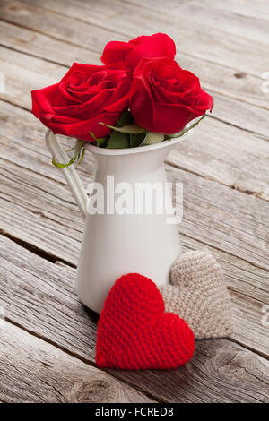 Rote Rosen und Herzen auf Holztisch. Valentinstag-Konzept Stockfoto