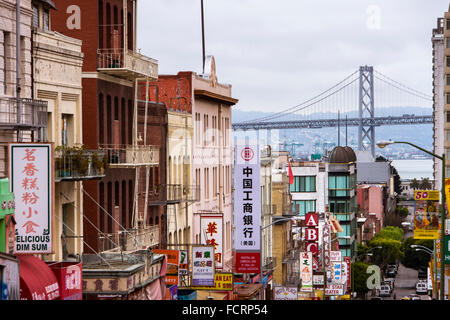 Blick durch die Zeichen der Chinatown mit Blick auf die Oakland Bay Bridge, San Francisco, Kalifornien Stockfoto