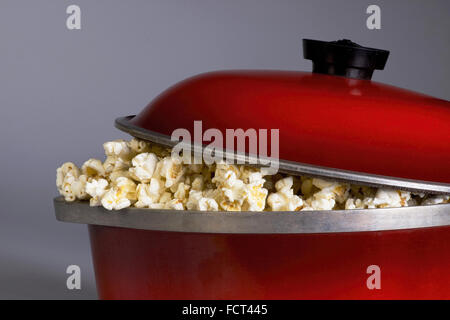 Knallende Popcorn die alte Weise in einem roten eisernen Topf. Stockfoto