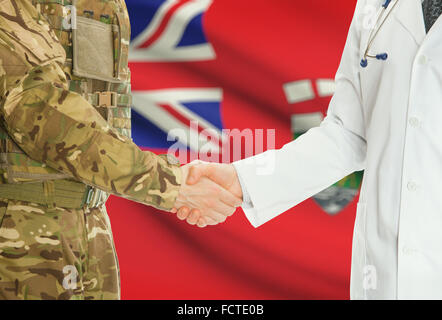 Soldaten in Uniform und Arzt Händeschütteln mit kanadischen Provinzen und Territorien Fahnen auf Hintergrund - Manitoba Stockfoto