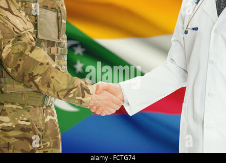 Soldaten in Uniform und Arzt Händeschütteln mit Nationalflagge auf Hintergrund - Komoren Stockfoto