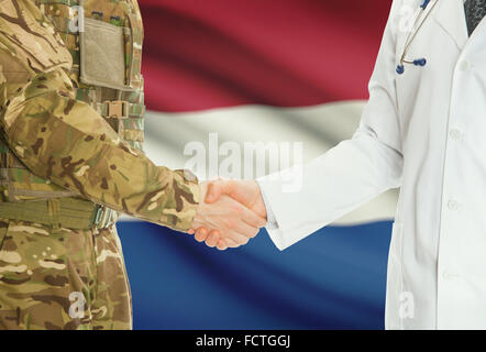 Soldaten in Uniform und Arzt Händeschütteln mit Nationalflagge auf Hintergrund - Niederlande Stockfoto