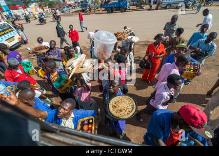 Straßenverkäufer verkaufen waren Menschen in den lokalen Bussen vorbei durch die Dörfer auf dem Weg heraus aus Kampala, Uganda, Afrika Stockfoto