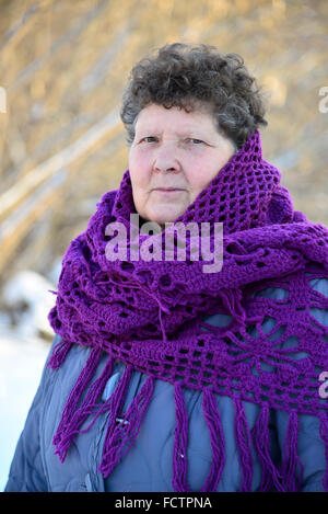 Frau mit lila gestrickten Schal auf seinen Schultern im Freien im winter Stockfoto