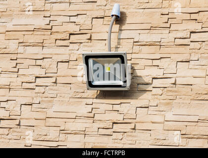 LED Flutlicht an Wand des Hauses mit lite braun dekorative Schiefer Steinwand Oberfläche bedeckt. Stockfoto
