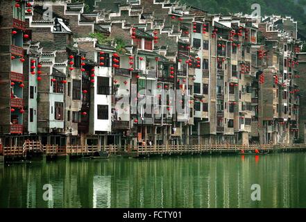 (160125)--Peking, 25. Januar 2016 (Xinhua)--rote Laternen hängen am Gebäude am Fluss in Zhenyuan Altstadt, Südwesten Chinas Provinz Guizhou, 26. Juli 2012. Laternen in China haben eine lange Geschichte, und sie sind gleichbedeutend mit der chinesischen Kultur geworden. Sie sind auch heute noch gemacht und von den Chinesen weltweit genossen. Sie dienten als Mittel des künstlerischen Ausdrucks, in Bezug auf Funktionalität, Design und Dekoration. Chinesische Straßen in Städten und Gemeinden sind mit roten Laternen während der Festivals, vor allem chinesischen Lunar New Year, Mid-Autumn Festival und Laterne Festiv eingerichtet. Stockfoto