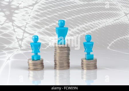 Ein Rüde und zwei weibliche Figuren stehen auf Pfählen von Münzen. Einkommens-Ungleichheit-Konzept. Stockfoto