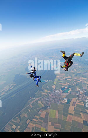 Zwei Freefly Fallschirmspringer bilden die Sit & kopfüber-Bildung. Dabei fliegen sie mit über 120 km/h Geschwindigkeit am Himmel zusammen. Stockfoto