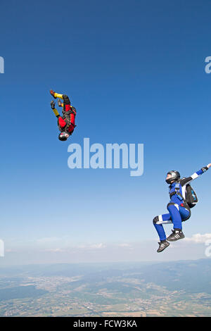 Zwei Freefly Fallschirmspringer bilden die Sit & kopfüber-Bildung. Dabei fliegen sie mit über 120 km/h Geschwindigkeit am Himmel zusammen. Stockfoto