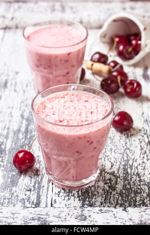 Smoothie mit Kirsche in einem Glas auf einem hölzernen Hintergrund Stockfoto