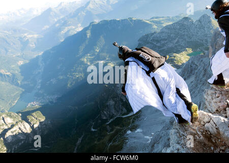 Diese zwei Wingsuit BASE-Jumper sind von einer Klippe verlassen. Sie werden bald fliegen gemeinsam in einer Formation und steigen am Berg entlang. Stockfoto