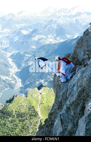 Diese zwei Wingsuit BASE-Jumper sind von einer Klippe verlassen. Sie werden bald fliegen gemeinsam in einer Formation und steigen am Berg entlang. Stockfoto