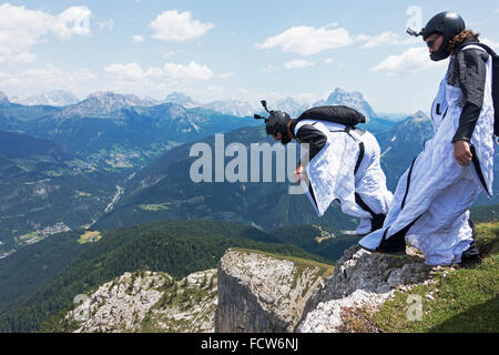 Diese zwei Wingsuit BASE-Jumper sind von einer Klippe verlassen. Sie werden bald fliegen gemeinsam in einer Formation und steigen am Berg entlang. Stockfoto