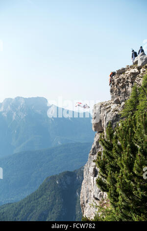 Wingsuit-Springer nur von einer Klippe zu verlassen und die anderen Springer beobachten ihn. Alle sind nervös und hoffe, dass sein Fallschirm funktioniert!? Stockfoto