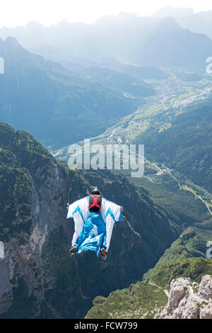 Dieses Wingsuit BASE-Jumper unten im Tal einige Klippen entlang nach oben schnellt. Dadurch fühlt er sich das Adrenalin in seinem Körper. Stockfoto