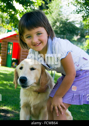 Streicheleinheiten und Umarmungen zwischen ein süßes kleines Mädchen und ihr Hund Stockfoto