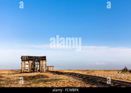 Verlassenes altes Fischerboot und Transport Bahnen auf dem Kiesstrand bei Dungeness in Kent, England Stockfoto