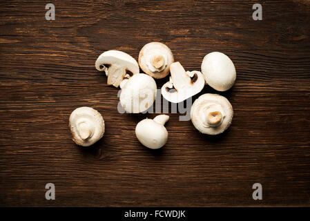 Frischen Champignons Champignons auf einem hölzernen Hintergrund. Stockfoto